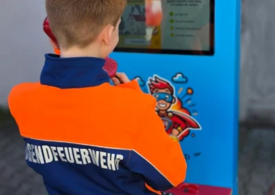 Ein Junge von der Jugendfeuerwehr telefoniert mit dem Notrufheld.