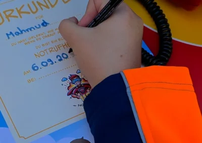 Eine Urkunde wird ausgestellt. Eine Kinderhand schreibt den Namen.