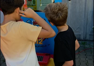 Kinder telefonieren mit dem Notrufheld.